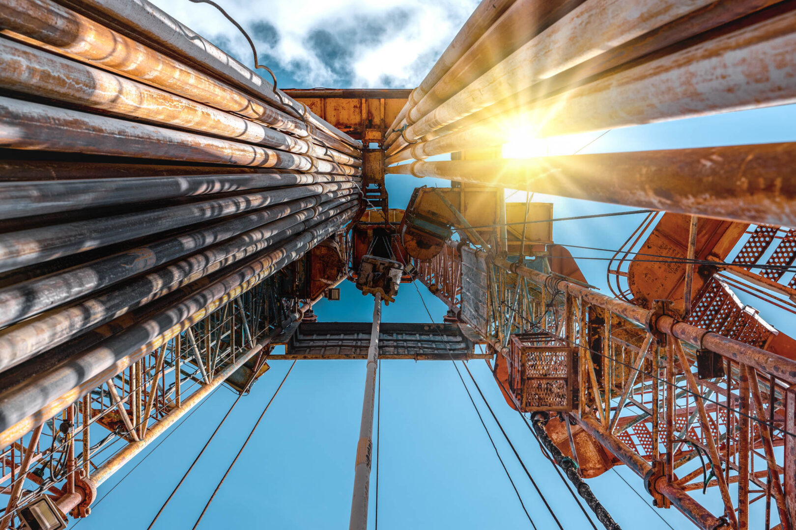 Oil and Gas Drilling Rig onshore dessert with dramatic cloudscape. Oil drilling rig operation on the oil platform in oil and gas industry.